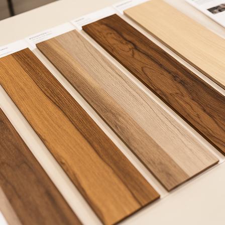 Mehrere Holzmuster nebeneinander auf einem Tisch, mit abgestuften Braun- und Beigetönen zur Materialvergleichung
